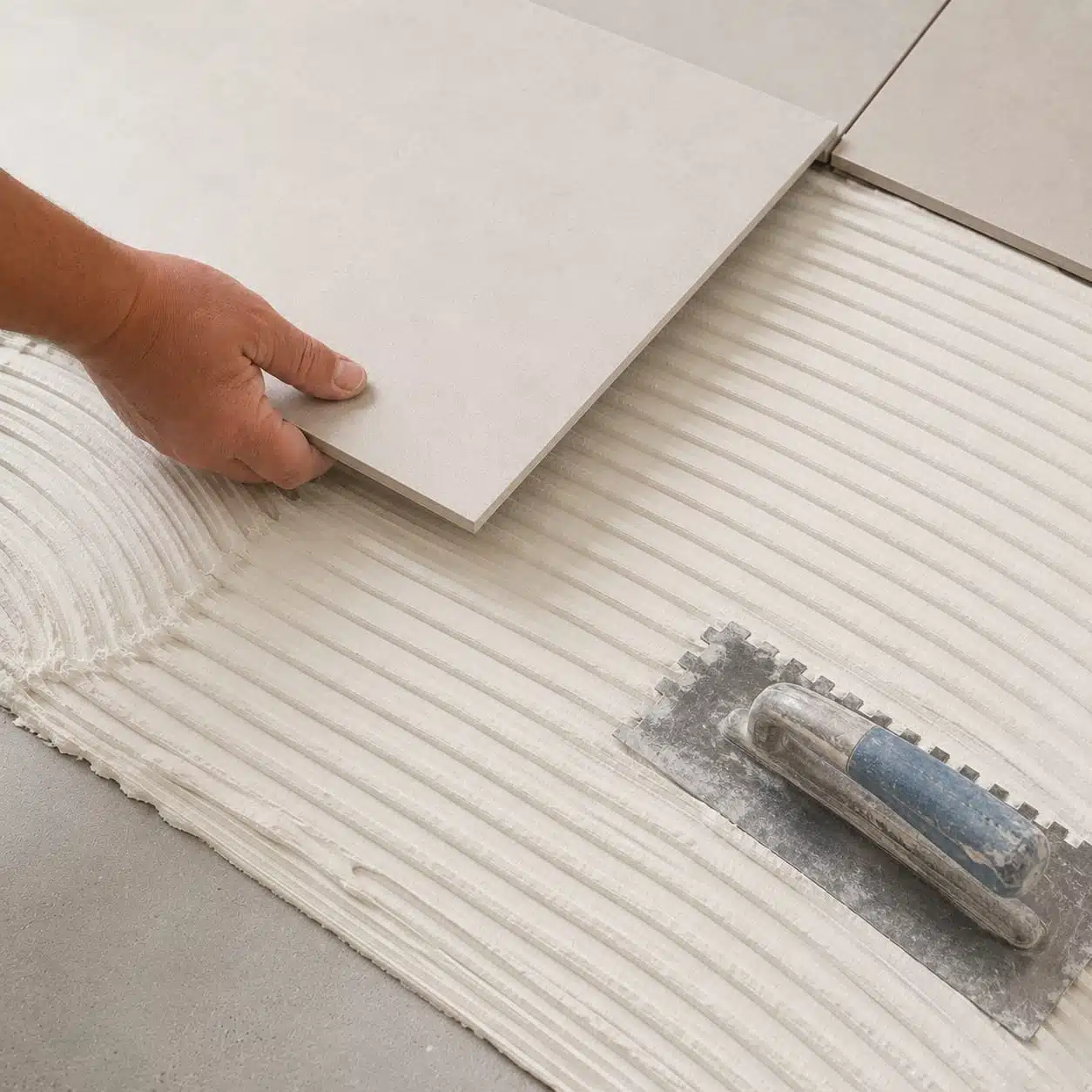 Tile being installed with adhesive