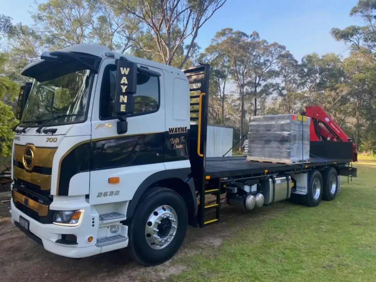 Wayne's crane truck carrying a pallet of tiles