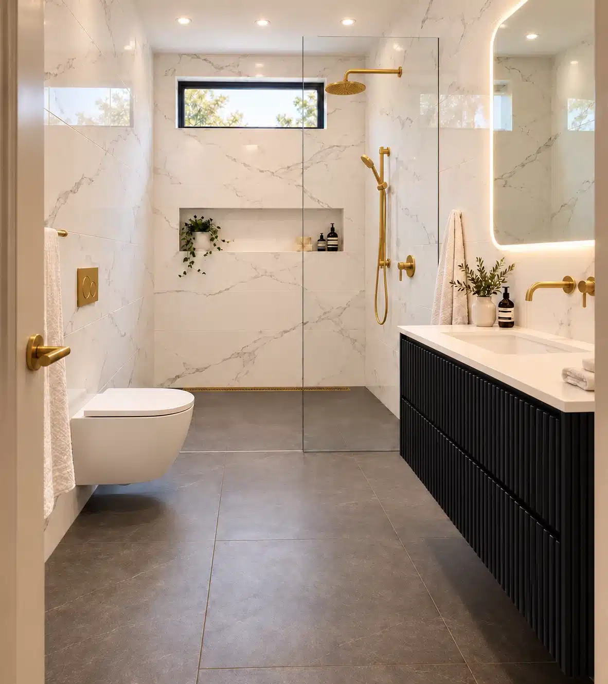 Small bathroom with Calacatta Deluxe polished 1200 by 600mm wall tiles, dark-grey Matt floor tiles, a black fluted floating vanity and brushed-gold taps, shower fittings and linear drain.